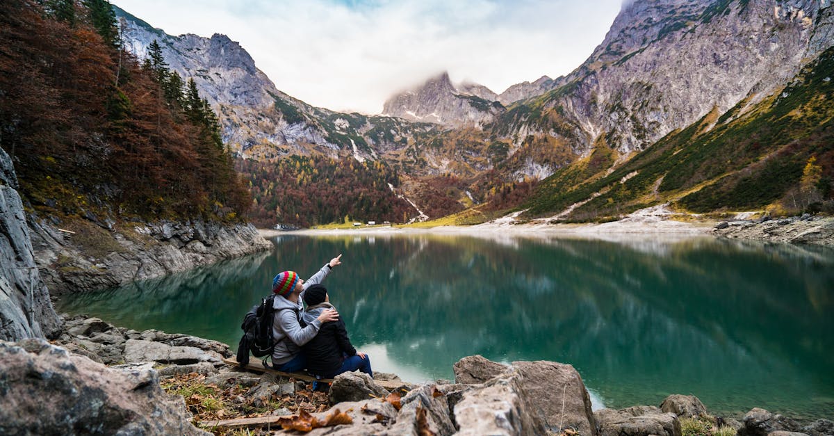 Couple assis sur un rocher près d'un lac