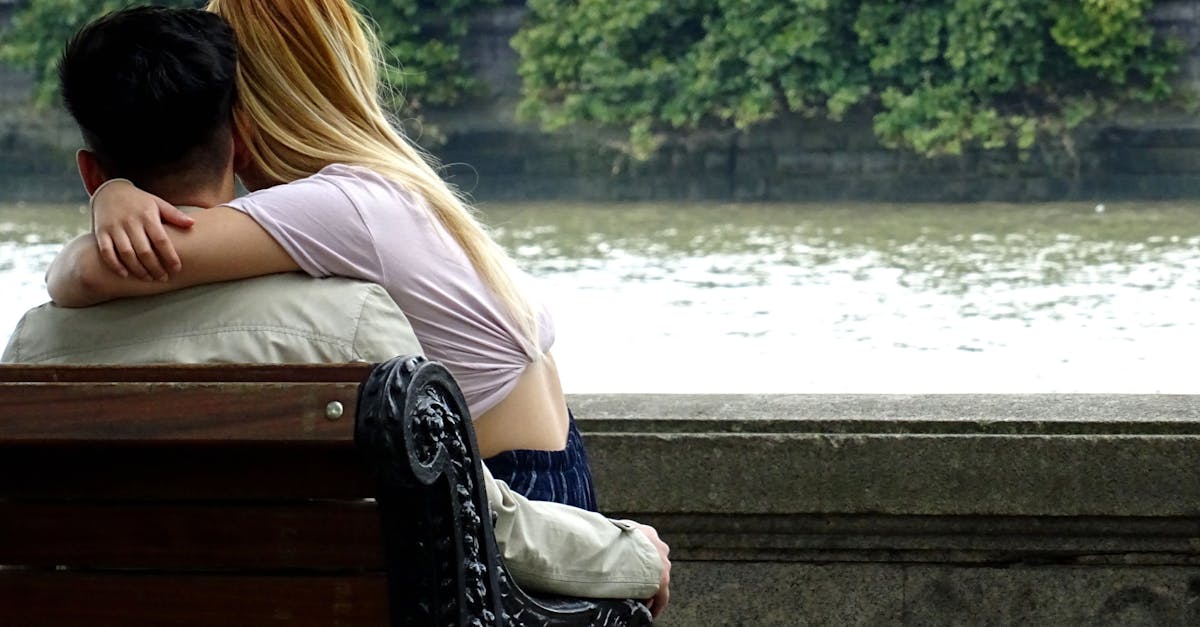 Homme et femme assis sur un banc avec vue sur la rivière.