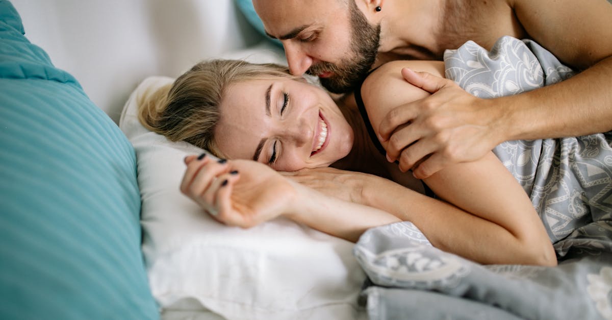 Couple heureux câlinant au lit le matin.