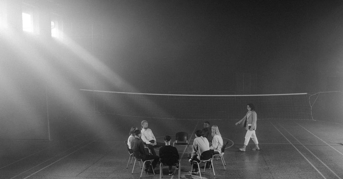 Photo en niveaux de gris de personnes assises sur des chaises