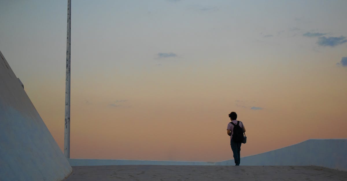 Photo de la silhouette d'une personne debout seule à la lumière dorée du crépuscule