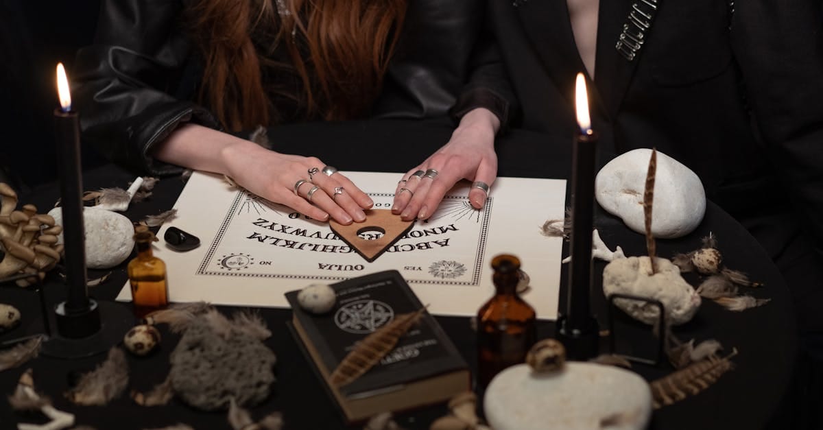Une scène mystérieuse où des personnes utilisent un plateau de Ouija, entourées de bougies et d'objets mystiques.