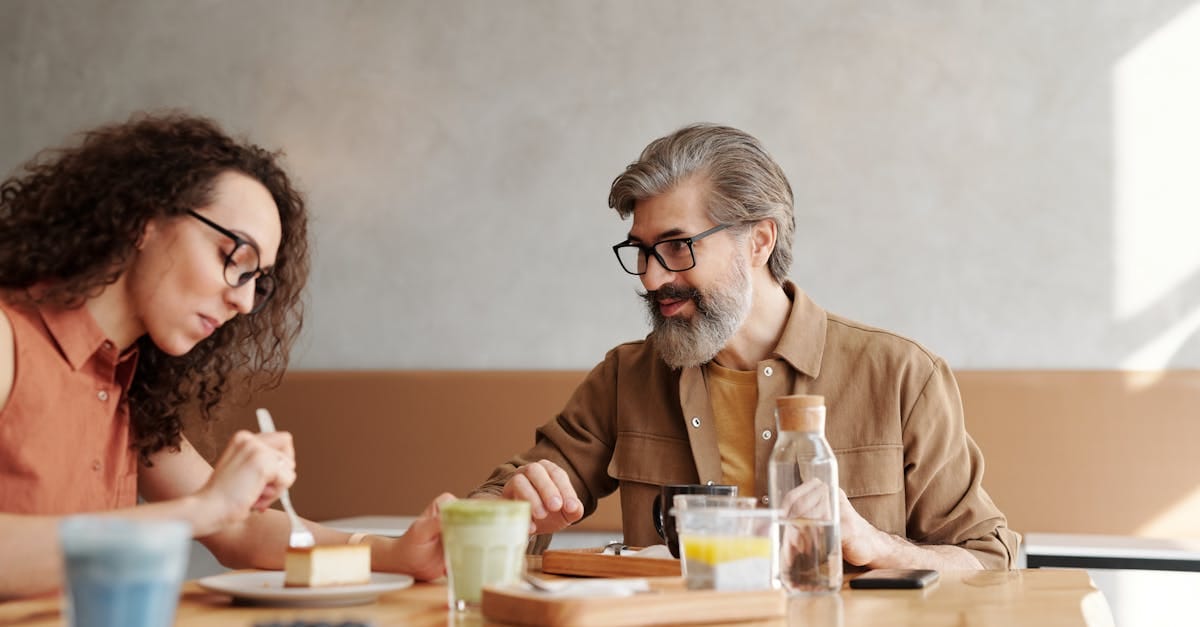 Un homme et une femme savourant des desserts et des boissons dans un cadre de café, immortalisés de manière naturelle.