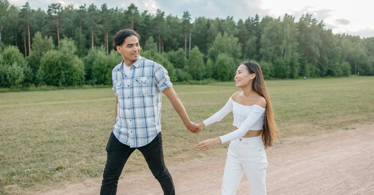 Un couple heureux se promenant main dans la main dans un parc verdoyant sous un ciel ensoleillé