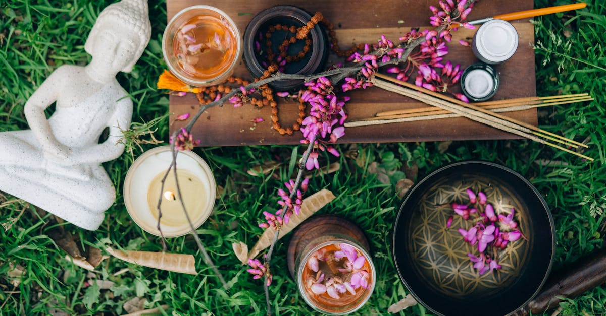 Scène de méditation extérieure paisible avec Bouddha, fleurs, encens et bougies.
