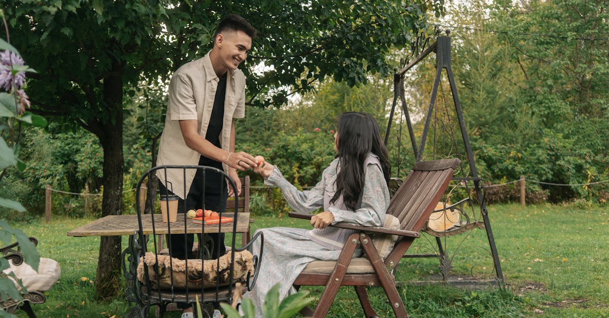 Un couple asiatique partage un moment dans un jardin paisible, sur une balançoire.